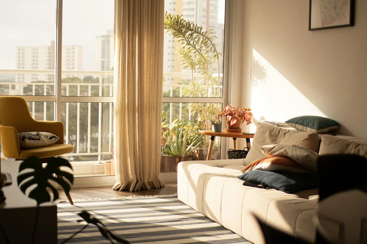 Sonniges Wohnzimmer mit Vorhang, Sofa und Pflanzen