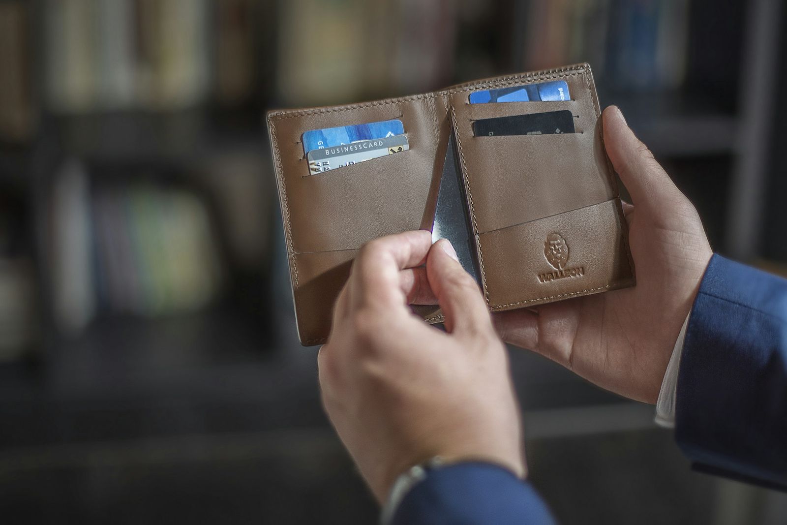 Hände nehmen eine Karte aus einer Brieftasche