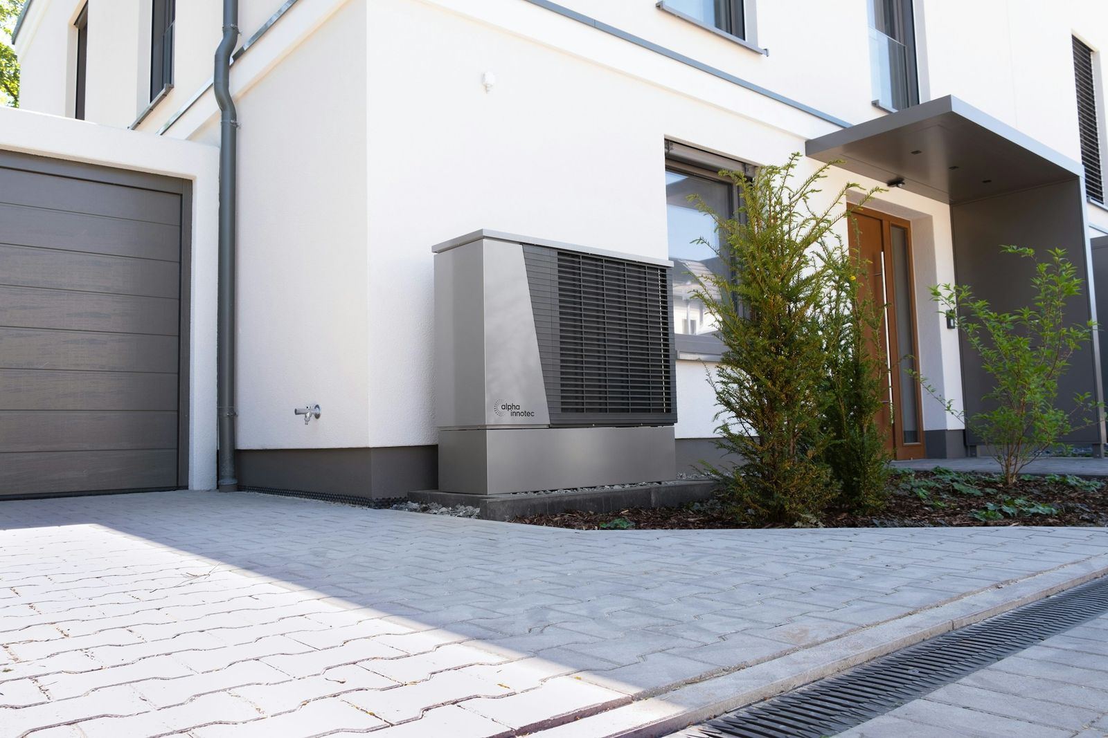 Eine Wärmepumpe vor einem modernen Einfamilienhaus